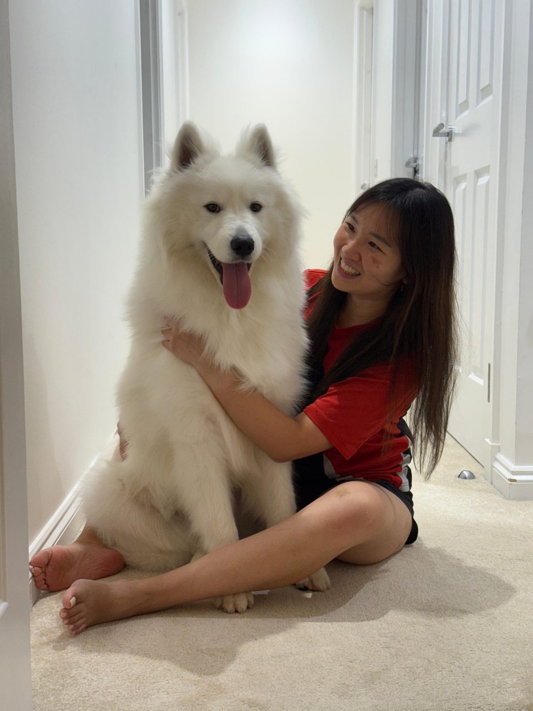 Yi Lin hugging their Samoyed